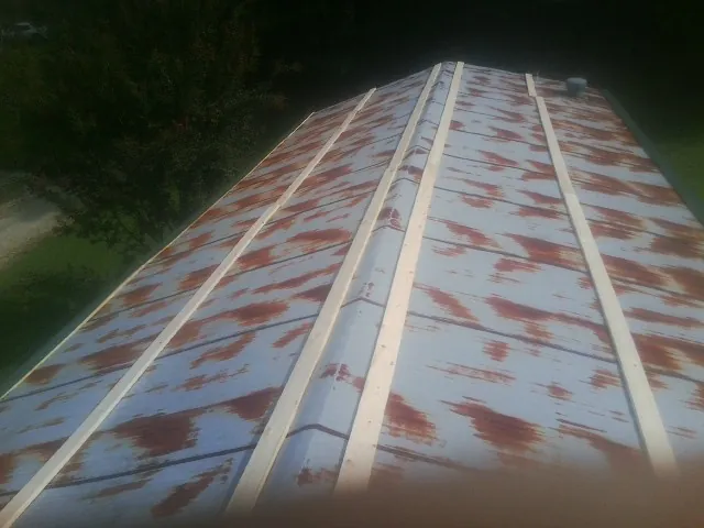 Rusted metal roof panels with new wood purlins before replacement — Storm Damage Roof Repair in Paige by Roofing Brothers