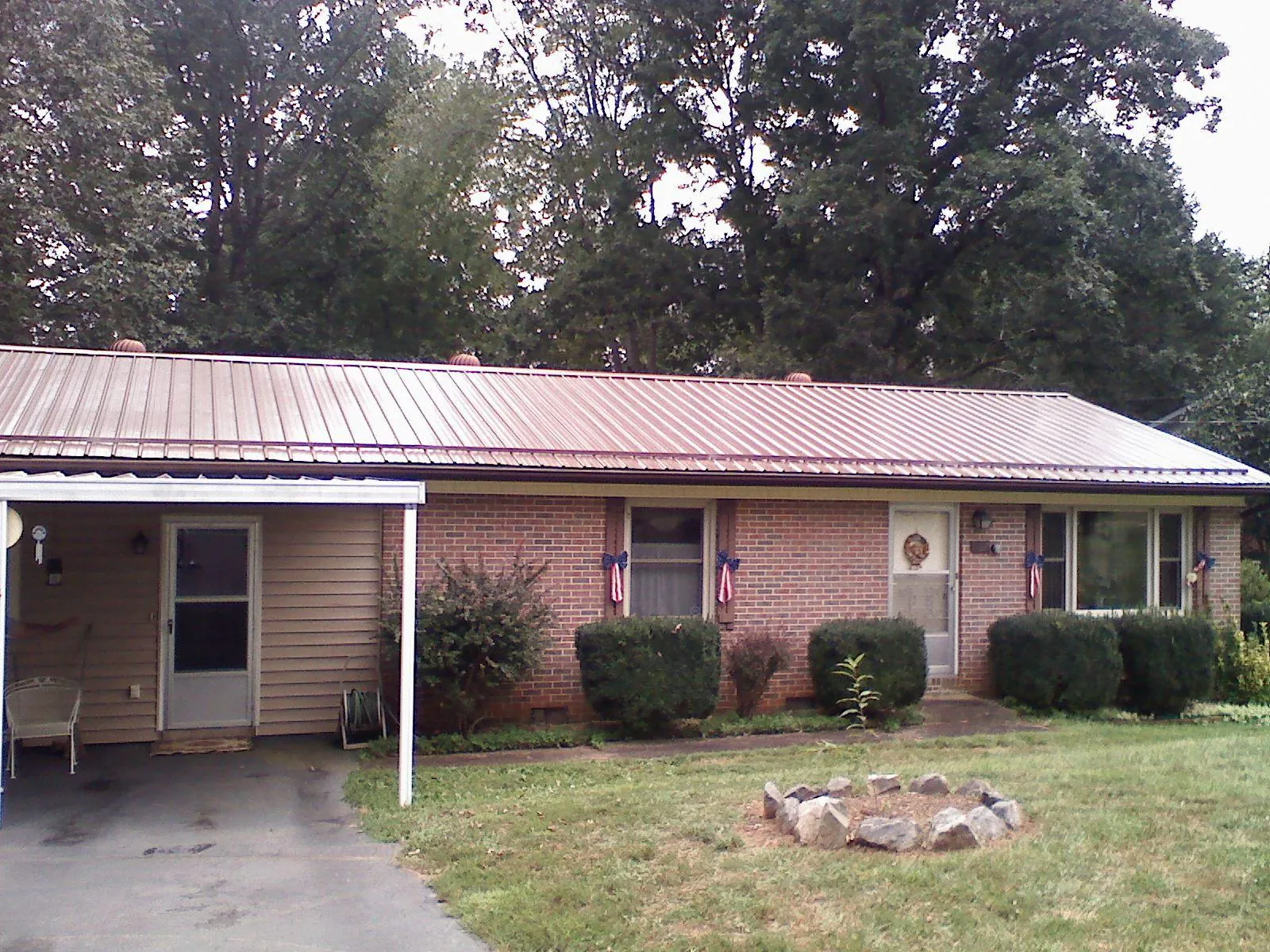 Bronze metal roof and carport on a brick ranch home — Roof Repair work by our crew in Paige
